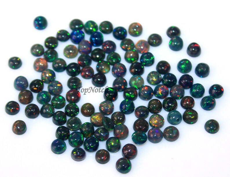 May include: A collection of 50 black opal cabochons, each measuring 6mm in diameter. The opals have a dark base with flashes of green, red, and blue.