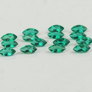 May include: A collection of 12 marquise-shaped green gemstones. The gemstones are faceted and have a brilliant shine.