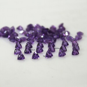 Peut inclure: Un groupe d'environ 40 petites pierres précieuses d'améthyste violettes de forme triangulaire.