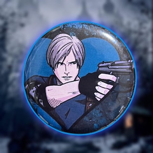 May include: A round button featuring a stylized illustration of a character with short, light-colored hair, holding a handgun. The character is wearing a dark blue jacket and black gloves. The button has a blue glowing border and a heart-shaped design.