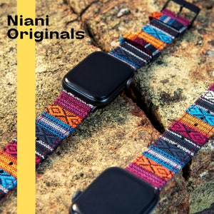 May include: A black smartwatch with a colorful woven band featuring geometric patterns in shades of red, orange, blue, and black. The band is attached to the watch with a black buckle. The text "Niani Originals" is visible.