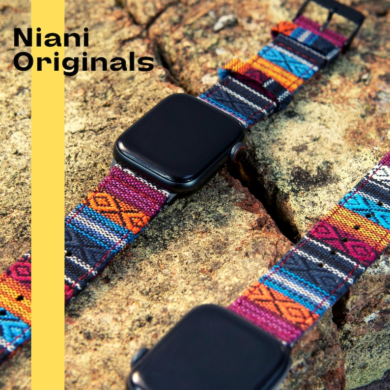 May include: A black smartwatch with a colorful woven band featuring geometric patterns in shades of red, orange, blue, and black. The band is attached to the watch with a black buckle. The text "Niani Originals" is visible.