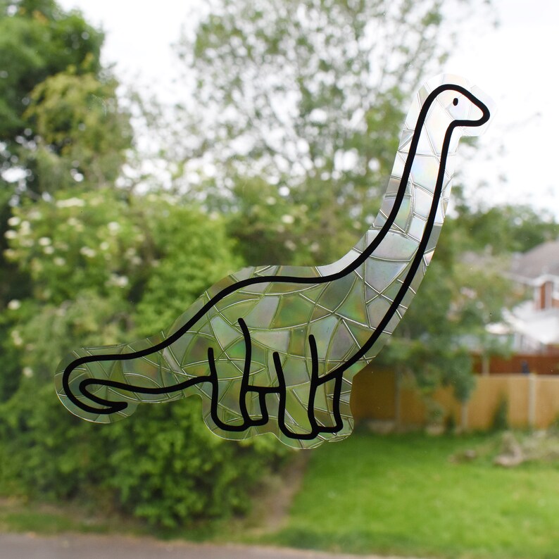 Pode incluir: Um contorno preto e branco de um dinossauro com um padr&atilde;o iridescente, semelhante a um mosaico. O dinossauro est&aacute; virado para a direita e tem um pesco&ccedil;o e uma cauda longos.