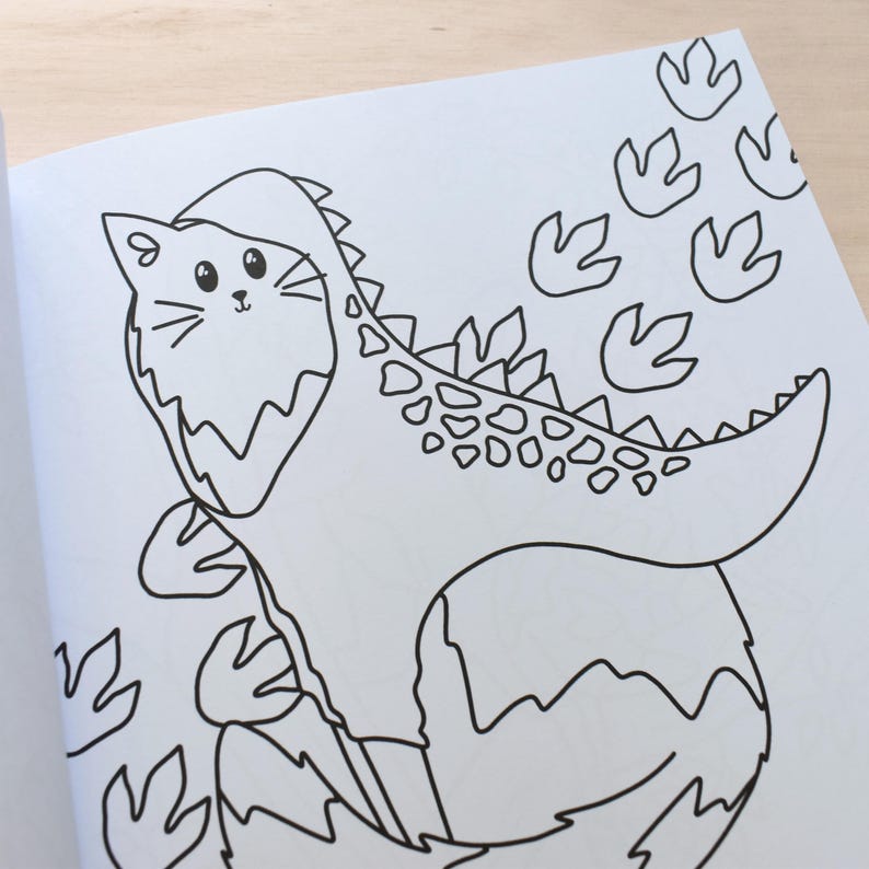 Pu&ograve; includere: Un disegno in bianco e nero di un gatto che indossa un costume da dinosauro. Il gatto &egrave; in piedi su una pianta frondosa e nell'angolo in alto a destra dell'immagine ci sono delle impronte di dinosauro.