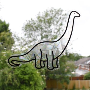 Pode incluir: Um contorno preto e branco de um dinossauro com uma textura iridescente, semelhante a um mosaico. O dinossauro est&aacute; virado para a direita e tem um pesco&ccedil;o comprido.