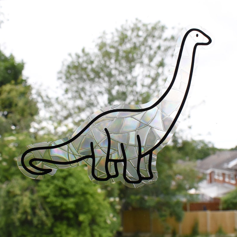 Pode incluir: Um contorno preto e branco de um dinossauro com uma textura iridescente, semelhante a um mosaico. O dinossauro est&aacute; virado para a direita e tem um pesco&ccedil;o comprido.