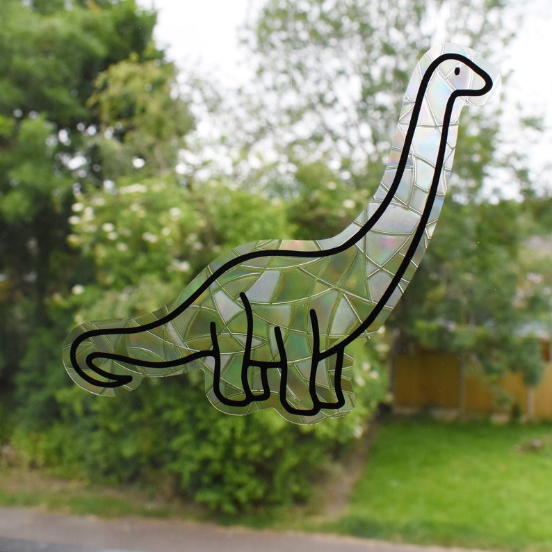 Pode incluir: Um desenho de linha preta de um dinossauro com uma textura iridescente, semelhante a um mosaico. O dinossauro est&aacute; olhando para a direita e tem um pesco&ccedil;o e uma cauda longos.