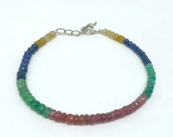 May include: A rainbow gemstone bracelet with a silver clasp. The bracelet features small, faceted beads in shades of yellow, blue, green, and pink.