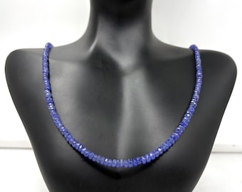 May include: A necklace of faceted, deep blue gemstones displayed on a black mannequin. The beads are small and uniform in size, creating a continuous strand. The necklace is a vibrant shade of blue.