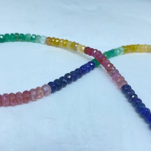 Könnte beinhalten: Eine mehrfarbige Edelsteinperlenkette mit rosa, blauen, grünen und gelben Perlen.