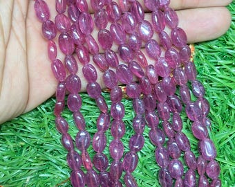 May include: A strand of pink oval-shaped gemstone beads. The beads are translucent and have a slight shimmer. The beads are strung on a clear thread and are approximately 8mm in diameter.
