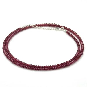 Op de afbeelding: Een delicate ketting met twee rijen kleine, ronde, donkerrode robijn kralen. De ketting is beveiligd met een zilveren sluiting.