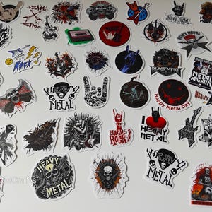 May include: A selection of heavy metal stickers featuring guitars, skulls, and hand gestures. Text includes "Heavy Metal", "Black Metal", and "Hard Rock". The stickers are in various colours, including red, black, and white.