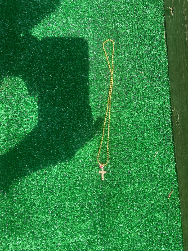 cross necklace with one colored bead