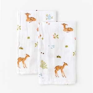 May include: Two white muslin baby burp cloths with a repeating pattern of brown deer, green leaves, and pink and blue flowers.