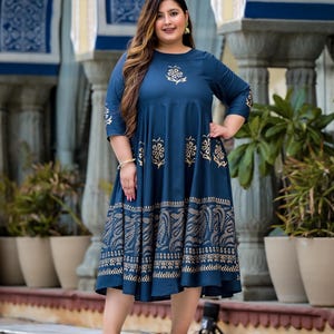 May include: A blue and gold printed midi dress with a round neckline and three-quarter sleeves. The dress has a floral pattern and a gold border.
