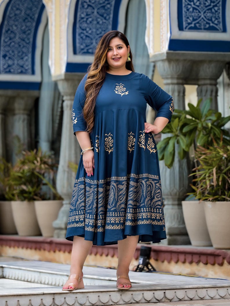 May include: A blue and gold printed midi dress with a round neckline and three-quarter sleeves. The dress has a floral pattern and a gold border.