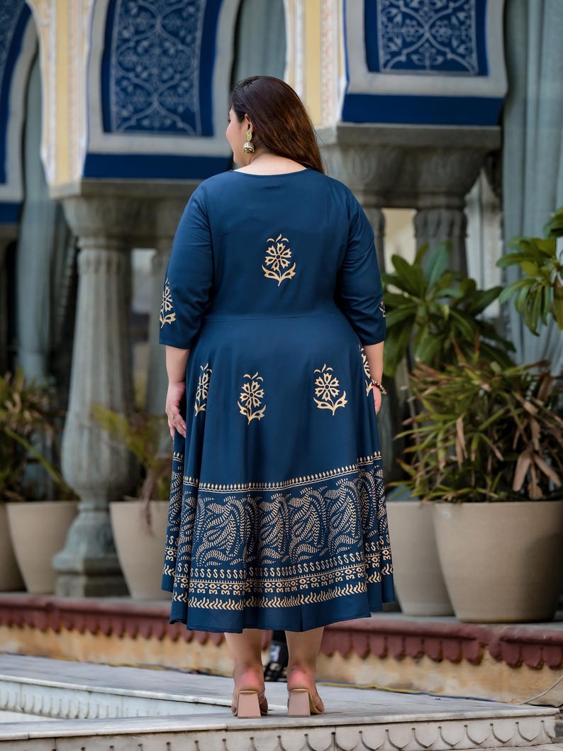 May include: A navy blue maxi dress with a gold floral print. The dress has a round neckline and three-quarter sleeves. The dress is made of a soft, comfortable fabric and has a flowy silhouette.