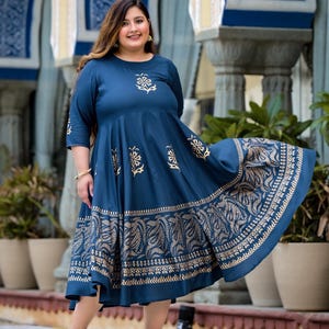 May include: A blue and gold printed maxi dress with a flared skirt. The dress has a round neckline and three-quarter sleeves.