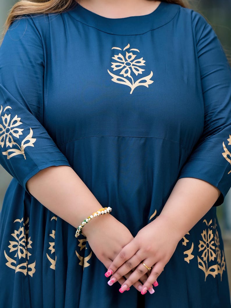 May include: A teal blue maxi dress with gold floral print. The dress has three-quarter sleeves and a round neckline.
