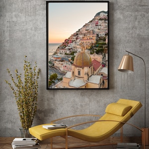 May include: A framed photograph of a colorful Italian village with a large church building in the center. The village is built on a hillside and the church has a large dome.