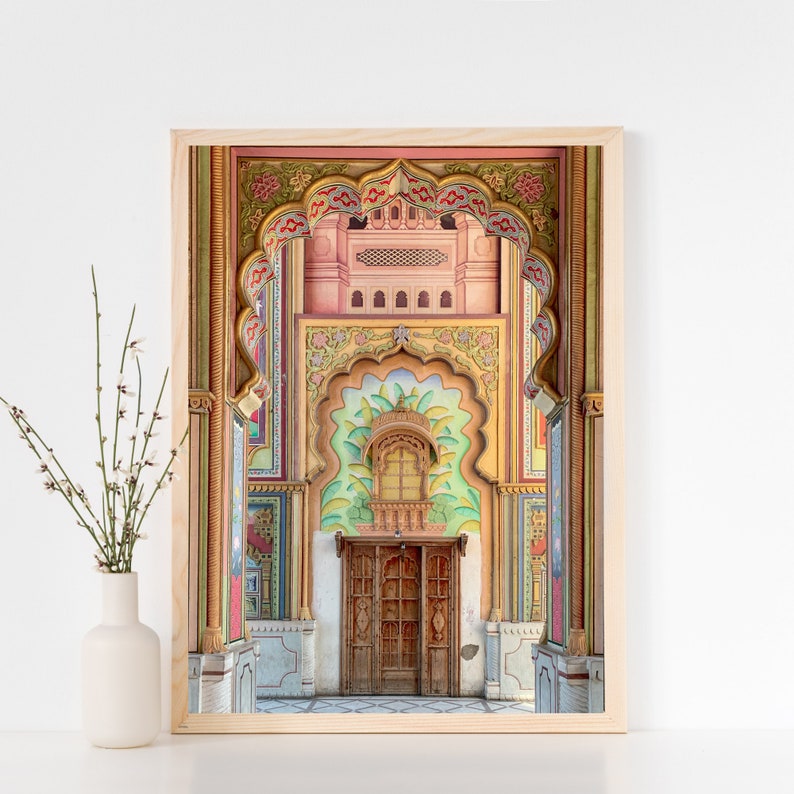May include: A colorful, ornate doorway with intricate carvings and arches. The doorway is painted in shades of pink, yellow, green, and blue. The door itself is made of wood and has a traditional design.