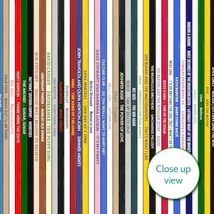 May include: A colorful image featuring a collection of vinyl record album spines. The titles and artists are visible, including ABBA, David Bowie, and Meat Loaf. The phrase "Close up view" is also present.