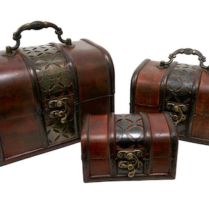 May include: Three wooden treasure chests with ornate metal accents and latches. The chests are brown and red with a distressed finish. The largest chest has a handle on the top.