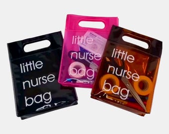 Może przedstawiać: Trzy przezroczyste torby z wycięciem na uchwyt. Na każdej torbie widnieje biały napis "little nurse bag". Torby są czarne, różowe i brązowe i zawierają materiały medyczne.