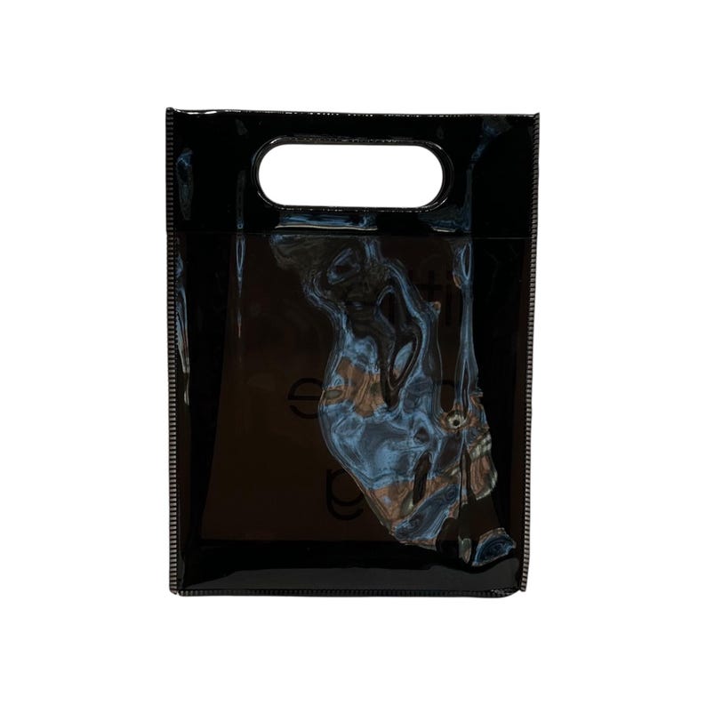May include: A glossy black tote bag with a rectangular shape and a handle at the top. The bag has a shiny, reflective surface and appears to be empty. The edges of the bag are neatly stitched.