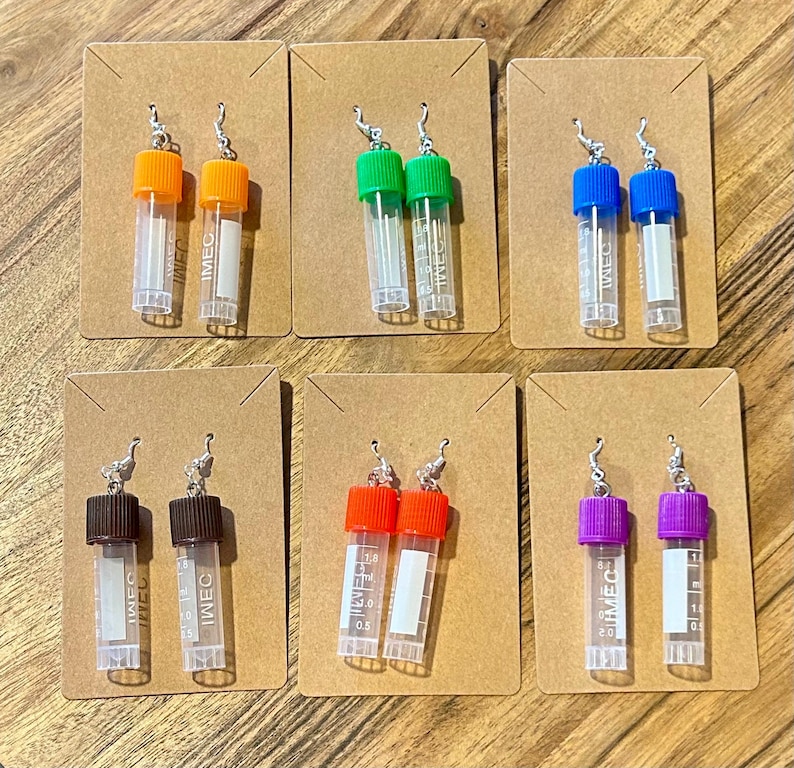 Puede incluir: Una colecci&oacute;n de seis pares de pendientes originales, cada uno con un peque&ntilde;o tubo de pl&aacute;stico transparente y una tapa de color. Las tapas son de color naranja, verde, azul, marr&oacute;n, rojo y morado. Cada pendiente est&aacute; unido a una peque&ntilde;a tarjeta marr&oacute;n.