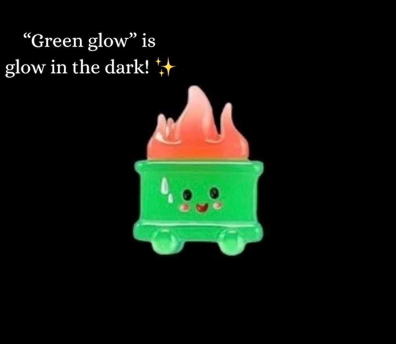 Może przedstawiać: Zielony, kresk&oacute;wkowy pojemnik na śmieci z uśmiechniętą twarzą i pomarańczowymi płomieniami na g&oacute;rze. Tekst "Green glow" is glow in the dark!" jest wyświetlany nad pojemnikiem na czarnym tle.