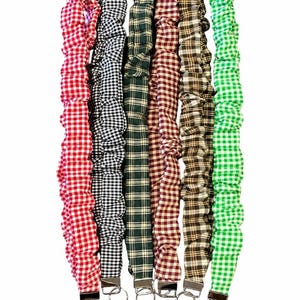 May include: Six fabric lanyards featuring gathered, elasticated designs in various plaid and gingham patterns, including red, black, dark green, maroon, and bright green, each finished with a silver-toned metal ring attachment.