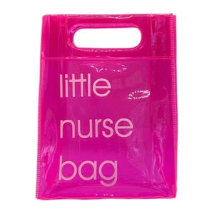 May include: A bright pink, transparent tote bag with a rectangular handle opening at the top. The words "little nurse bag" are printed in white, centered on the front of the bag. The bag is made of a shiny, clear material.