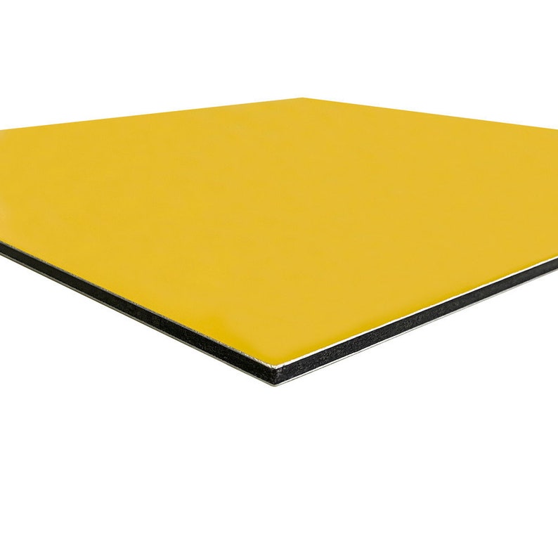May include: A square, yellow panel with a smooth, glossy surface. The edges are black with a silver lining. The panel is set against a white background.