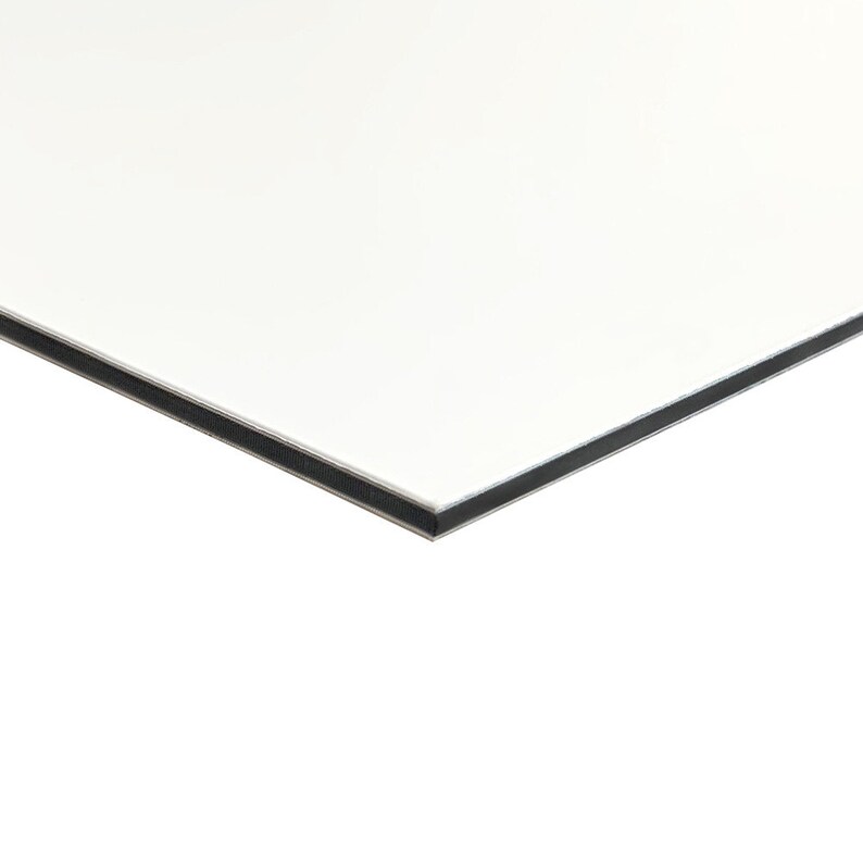 May include: A white rectangular panel with a black border. The panel is angled, showing the edge and a portion of the surface. The surface is smooth and reflective, with a clean, modern aesthetic. The black border adds contrast to the white surface.