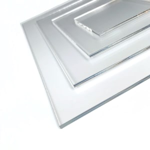 Peut inclure: Une pile de feuilles acryliques transparentes de différentes tailles, disposées en couches. Le matériau transparent laisse passer la lumière, créant une esthétique épurée et moderne. Les bords des feuilles sont lisses et polis.