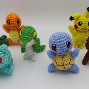 May include: Six crocheted Pokemon characters: Bulbasaur, Charmander, Squirtle, Pikachu,  Eevee, and  a green and white character.