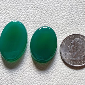 Può includere: Due cabochon ovali in agata verde, ciascuno delle dimensioni di una moneta da 25 centesimi di dollaro americano.
