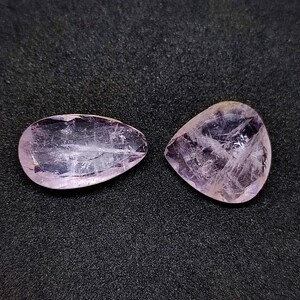 May include: Two pear-shaped, translucent, light purple gemstones with a rough, natural finish.