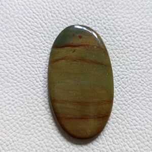Può includere: Cabochon ovale di agata con bande verde, marrone e rosso.