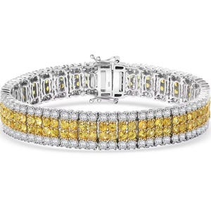 May include: A silver tennis bracelet with three rows of yellow and white gemstones. The bracelet has a secure clasp.