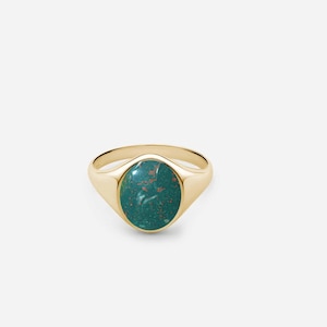 May include: A gold signet ring with a green oval gemstone. The gemstone has a marbled pattern with hints of brown.