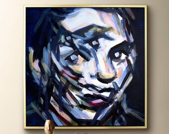 May include: Abstract painting of a person's face with bold brushstrokes in shades of blue, white, black, and red. The painting is framed in gold.