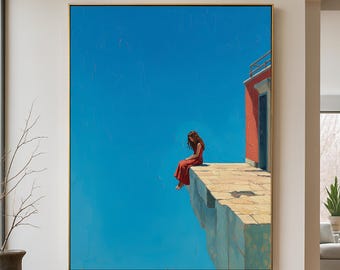 May include: A framed painting depicts a person in a red dress sitting on the edge of a stone structure against a bright blue sky. A red building with a door and railing is visible. The artwork has a gold frame.