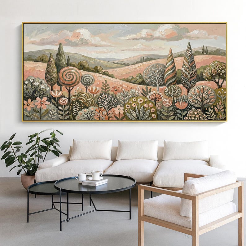Pu&ograve; includere: Un dipinto a olio di un paesaggio con dolci colline, alberi e fiori nei toni del rosa, verde e marrone. L'opera &egrave; incorniciata in oro e appesa sopra un divano bianco e un tavolino nero.
