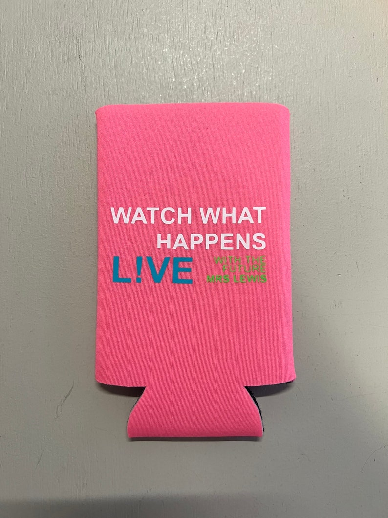 May include: A pink beverage can cooler with the text "WATCH WHAT HAPPENS LIVE" in white and blue. The bottom of the cooler has a black trim. The text "WITH THE FUTURE MRS LEWIS" is in green.