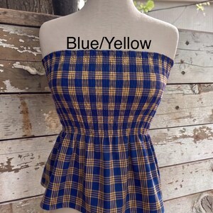 Peut inclure: Un haut bustier sans bretelles avec un motif &agrave; carreaux bleu et jaune, dot&eacute; d'un corsage smock&eacute; et d'un ourlet &agrave; basque &eacute;vas&eacute;. Le texte Blue/Yellow est imprim&eacute; sur la partie sup&eacute;rieure du v&ecirc;tement, pr&eacute;sent&eacute; sur un buste de mannequin.