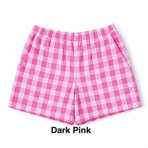 K&ouml;nnte beinhalten: Eine Shorts mit einem lebendigen dunkelrosa-wei&szlig;en Karomuster. Die Shorts verf&uuml;gt &uuml;ber einen elastischen Bund und zwei Seitentaschen. Der Stoff zeigt ein durchgehendes, gleichm&auml;&szlig;iges Gitterdesign, das dem Kleidungsst&uuml;ck eine strukturierte Optik verleiht.