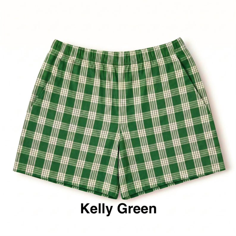 K&ouml;nnte beinhalten: Kellygr&uuml;ne Shorts mit einem wei&szlig;en und dunkelgr&uuml;nen Karomuster. Die Shorts verf&uuml;gen &uuml;ber einen elastischen Bund und zwei Seitentaschen. Der Text "Kelly Green" ist unter dem Kleidungsst&uuml;ck in Schwarz gedruckt und benennt die Farbe.